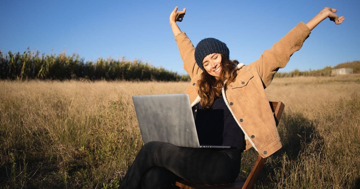 Un nómada digital disfrutando de su trabajo en medio del campo